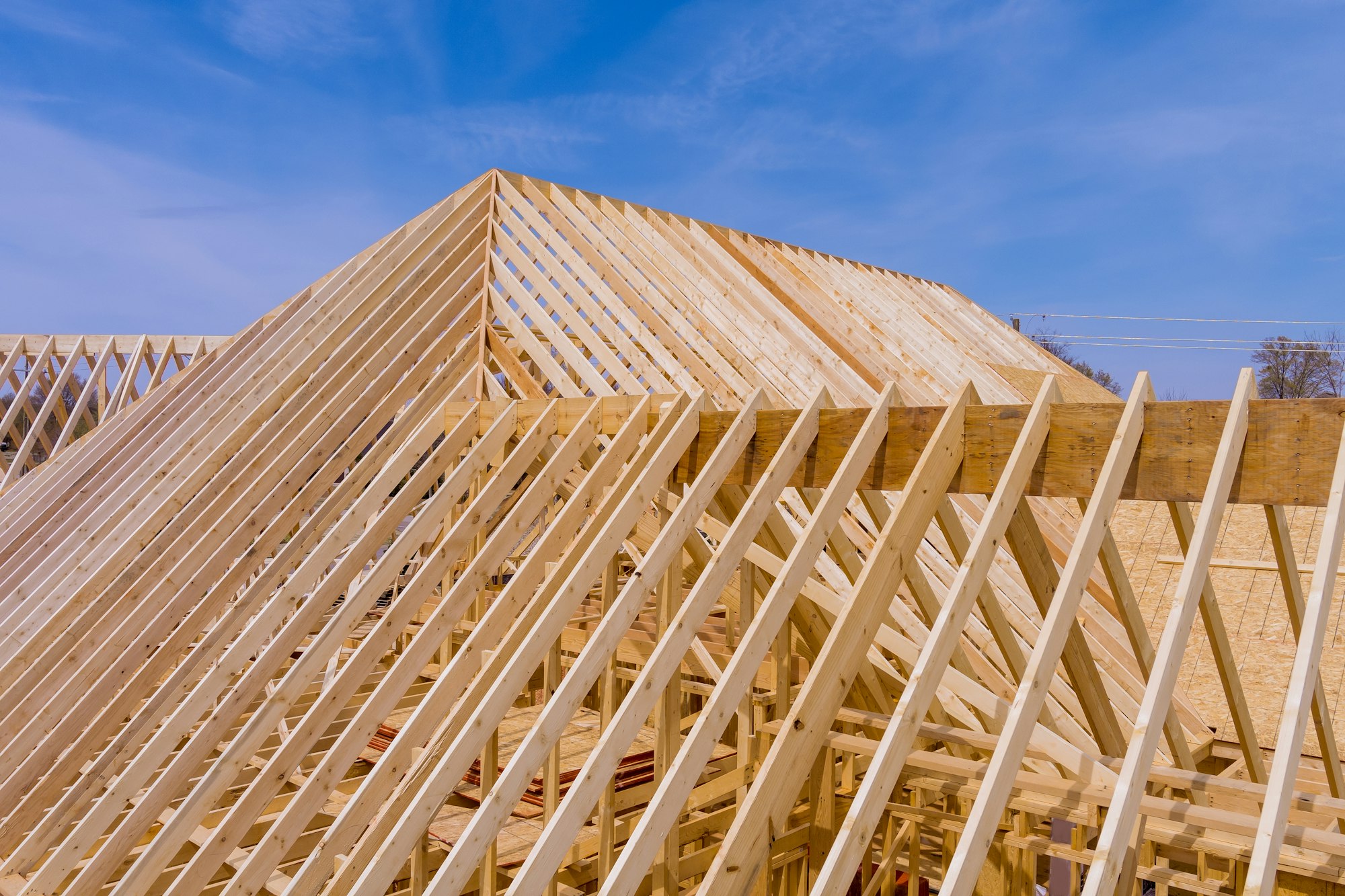 Installation of wooden with roof beams frame trusses condominium construction